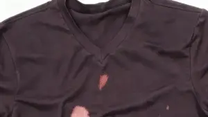 Maglietta scura con evidenti macchie di candeggina sul davanti